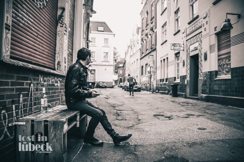 Clemensstrasse Lübeck Mann sitzt auf Palettenbank Graffiti